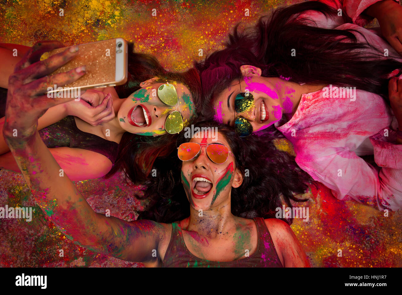 Drei indische Mädchen findet Selfie während Holi Color festival Stockfoto