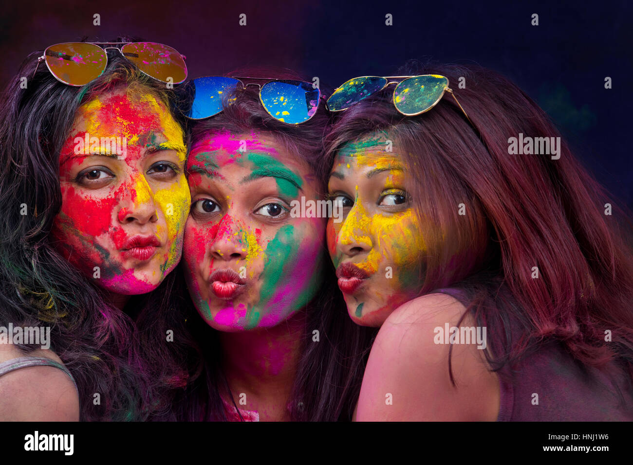 Porträt von drei jungen indischen Frauen mit farbigen während Holi Flächenfarbe festival Stockfoto