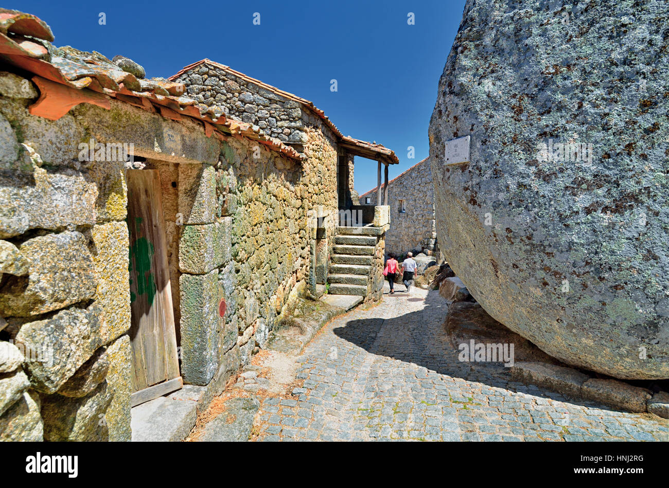 Portugal: Kleine Gasse vorbei an Häusern aus Stein Granit und riesige Felsen in Monsanto Stockfoto