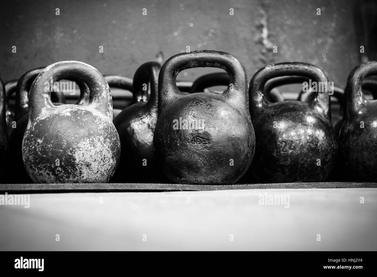 Alte abgenutzte Hanteln im Fitnessstudio in schwarz / weiß Stockfoto
