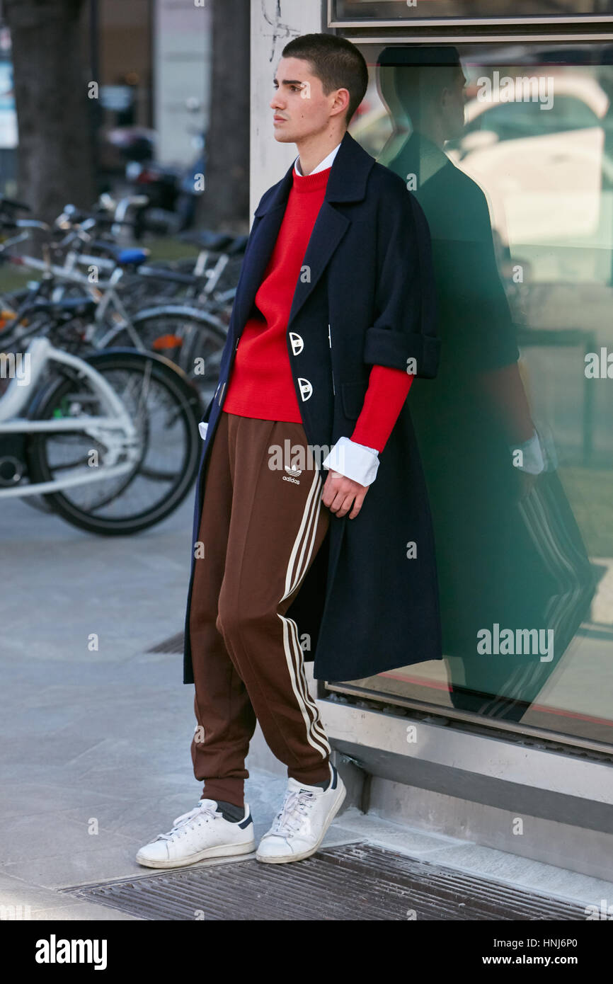 Mann mit braunen Adidas Hosen und roten Pullover vor Emporio Armani-Modenschau, Milan Fashion Week Streetstyle am Januar Stockfoto