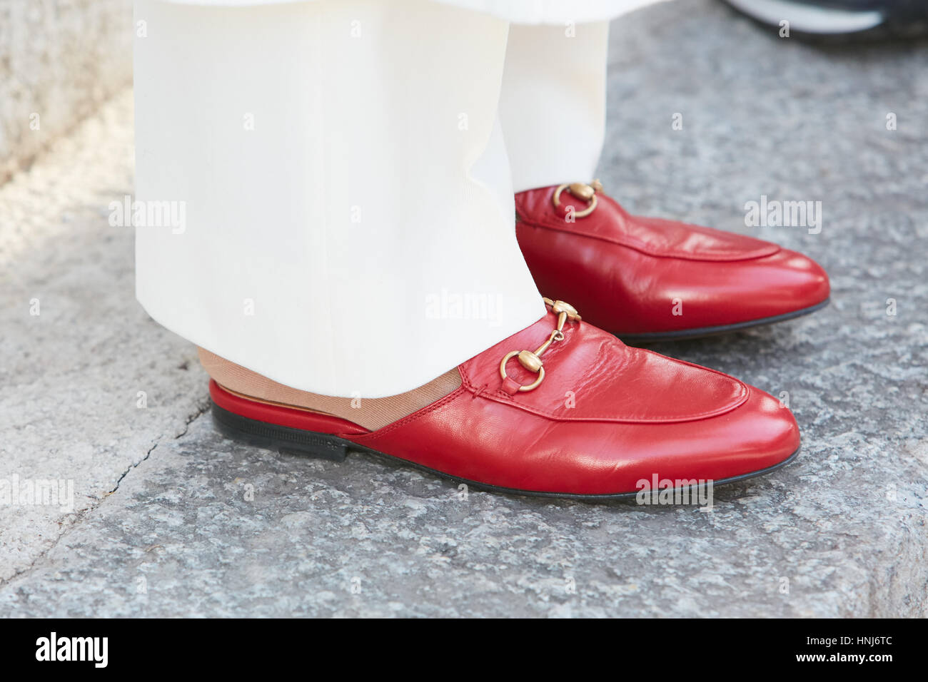 Frau mit roten Gucci Schuhe und weiße Hosen vor Emporio Armani-Modenschau, Milan Fashion Week Streetstyle am Januar Stockfoto