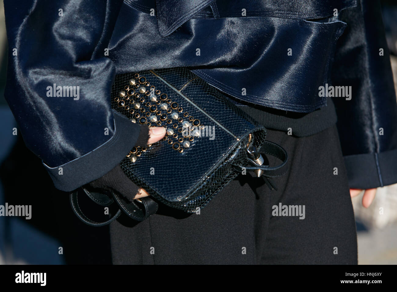 Frau mit dunklen blauen Jacke und Reptil Ledertasche vor Salvatore Ferragamo Modenschau, Milan Fashion Week Streetstyle am Januar Stockfoto