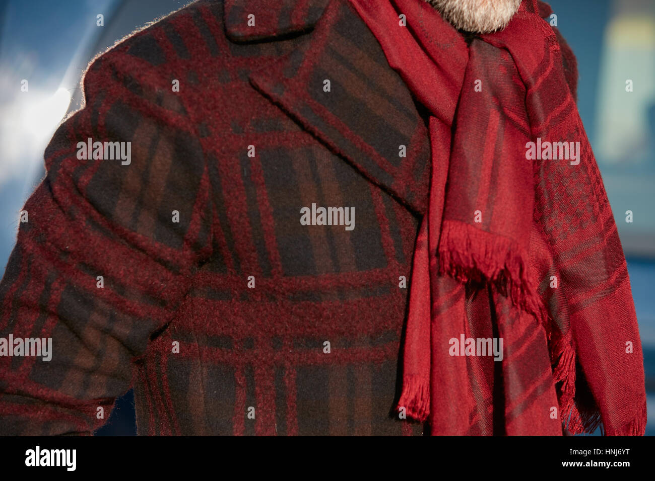 Mann mit rotem Schal und dunklen roten Mantel vor Salvatore Ferragamo Modenschau, Milan Fashion Week Streetstyle am 15. Januar 2017 Stockfoto