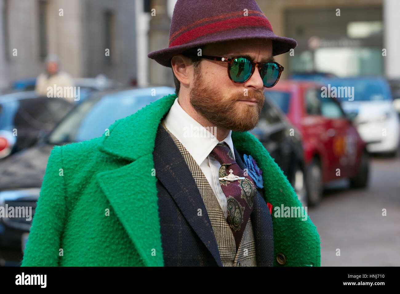 Mann mit grünen Jacke und lila Hut vor Salvatore Ferragamo Modenschau, Milan Fashion Week Streetstyle am 15. Januar 2017 Stockfoto