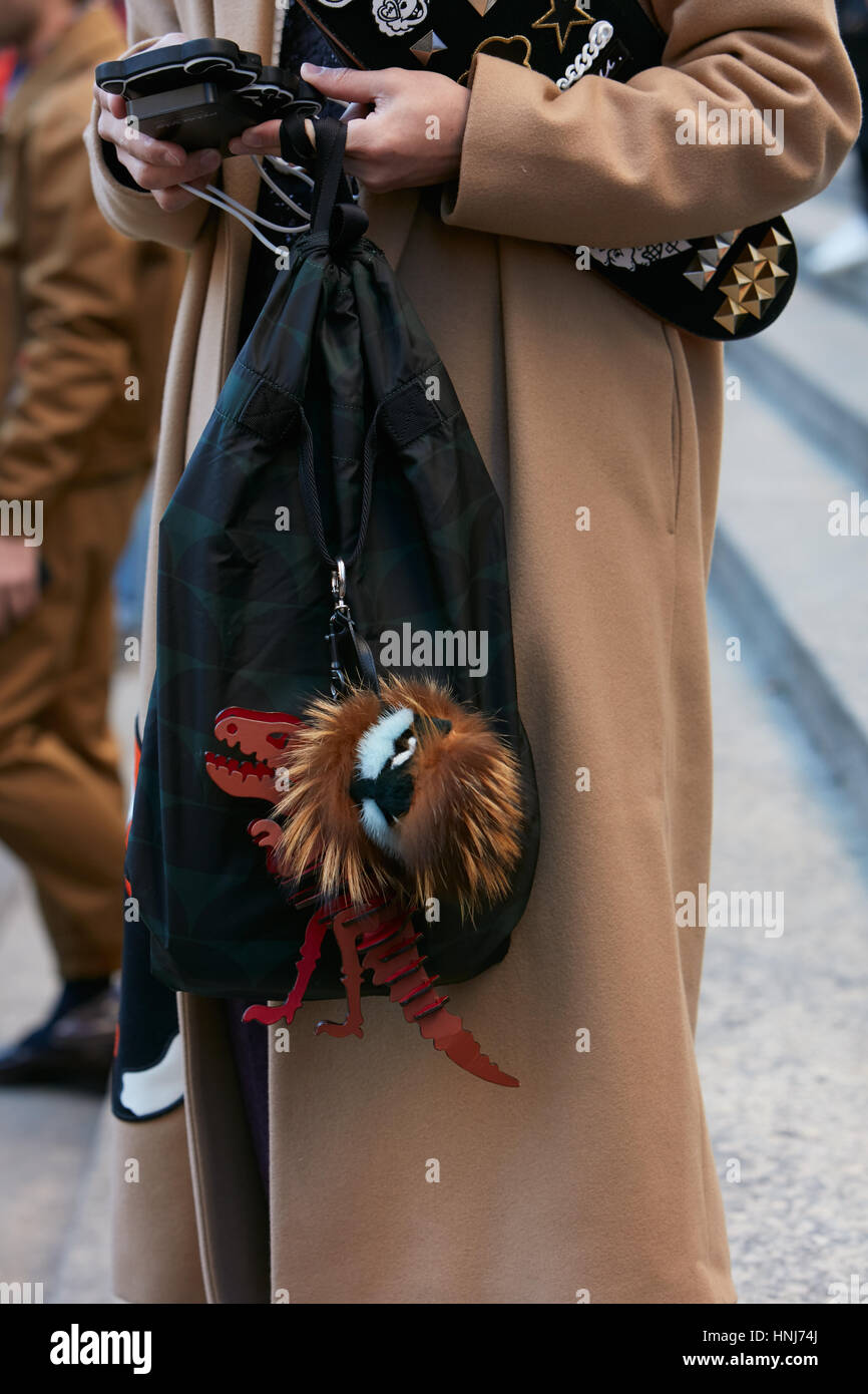 Mann mit beigefarbenen Mantel und Rucksack mit hölzernen Dinosaurier vor Salvatore Ferragamo Modenschau, Milan Fashion Week Streetstyle am Januar 2017. Stockfoto