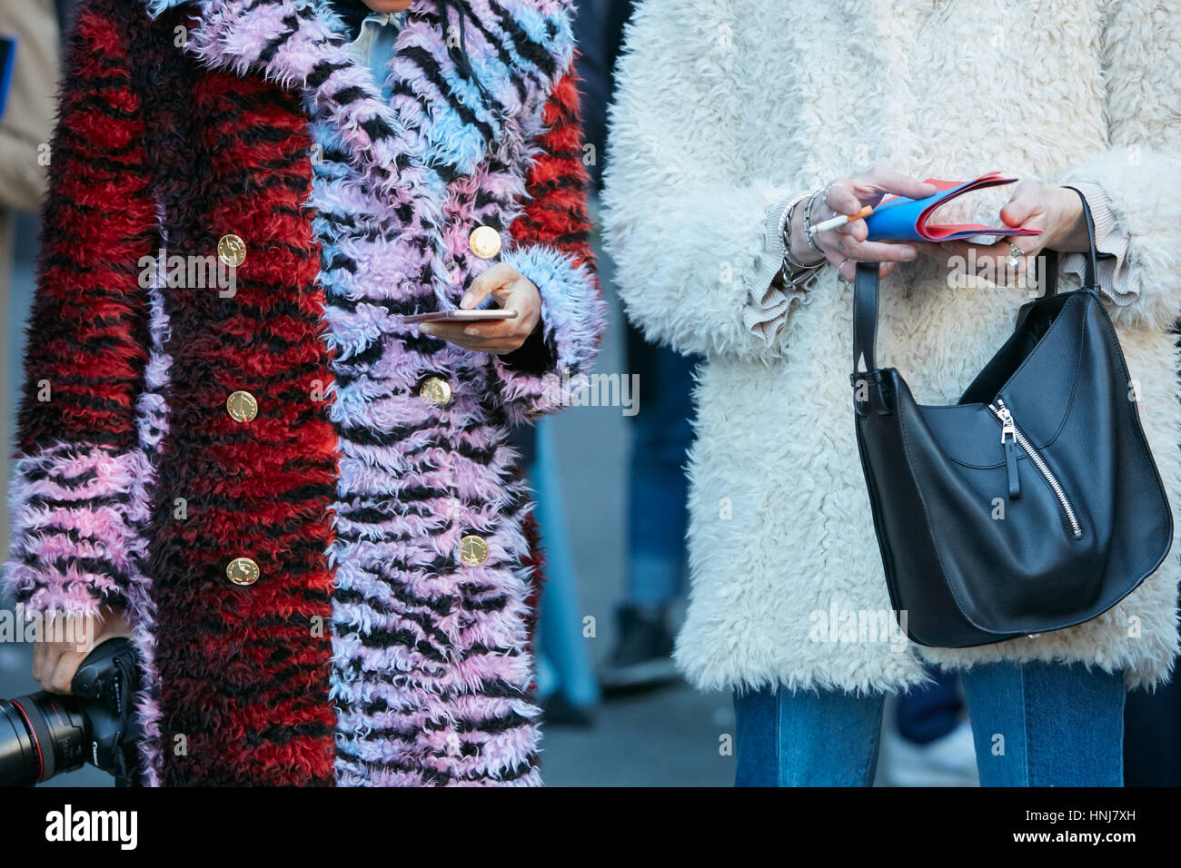 Frauen mit weißen und roten Pelzmantel bevor MSGM Modenschau, Milan Fashion Week Streetstyle am 16. Januar 2017 in Mailand. Stockfoto