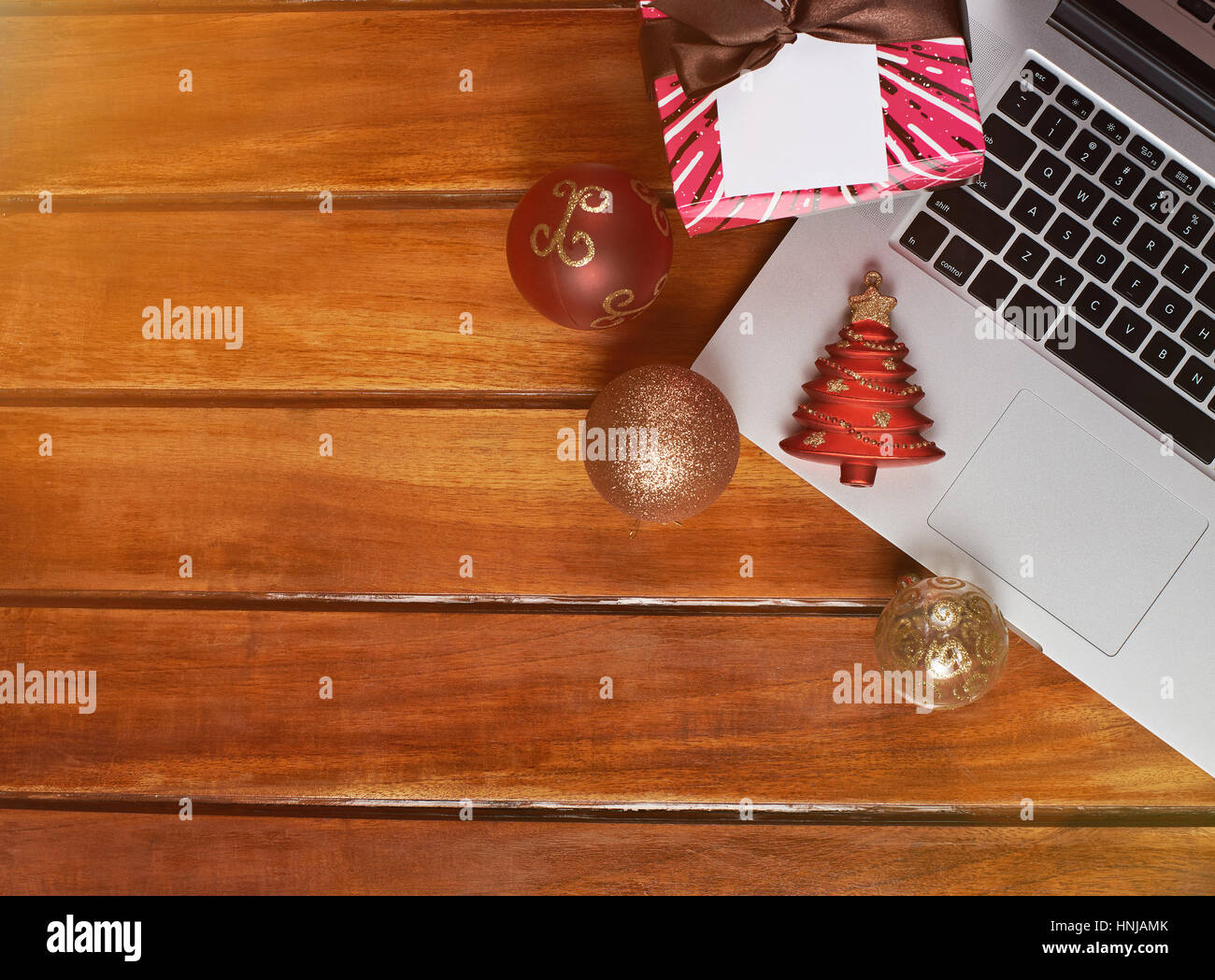 Holztisch mit Weihnachtsschmuck und Laptop. Weihnachtsgeschenke, Santa fordern. Stockfoto