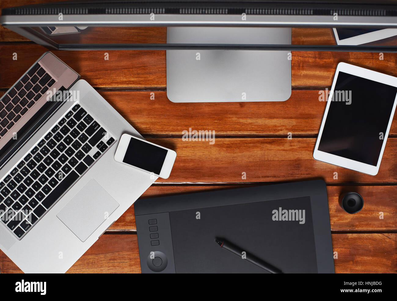 Draufsicht auf Retoucher Gadgets auf Holztisch mit Laptop, Tablet und leeren Raum Stockfoto