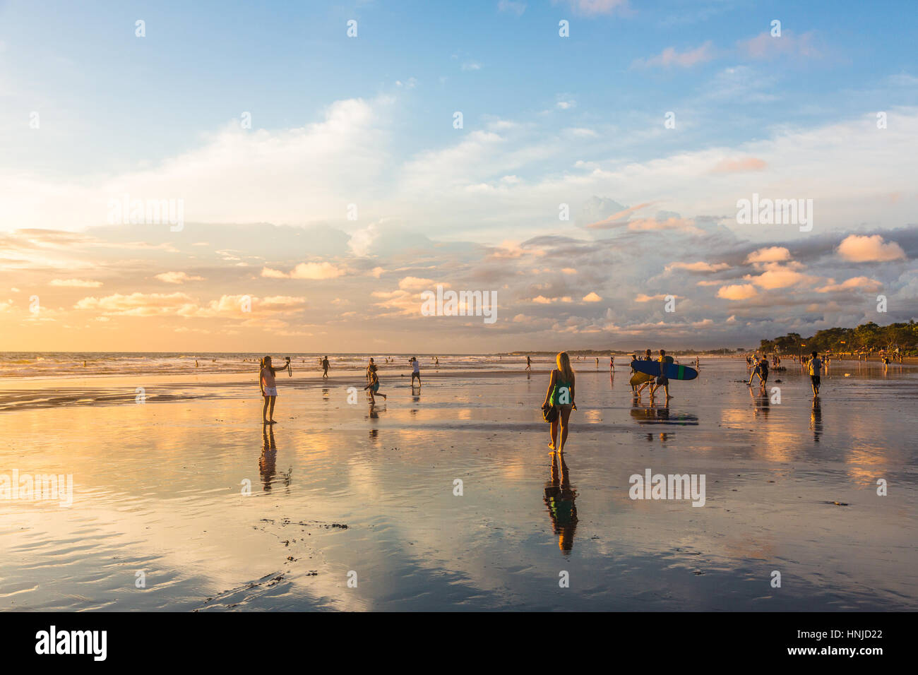 BALI, Indonesien - 21. Februar 2016: Touristen genießen Sie einen atemberaubenden Sonnenuntergang am Strand von Kuta im Bereich Seminyak der beliebten Insel in Indonesien. Stockfoto