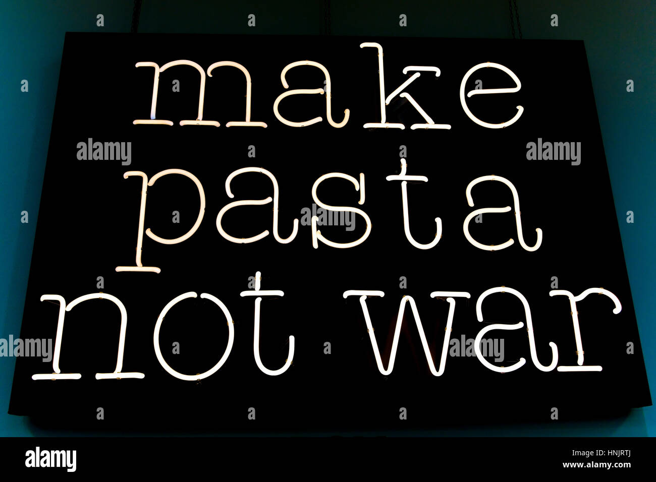Machen Sie Nudeln nicht Krieg. Konzept ironisch Friedensbotschaft gegen Krieg, für Pasta. Weiße Leuchtreklame auf schwarzem Hintergrund. Stockfoto