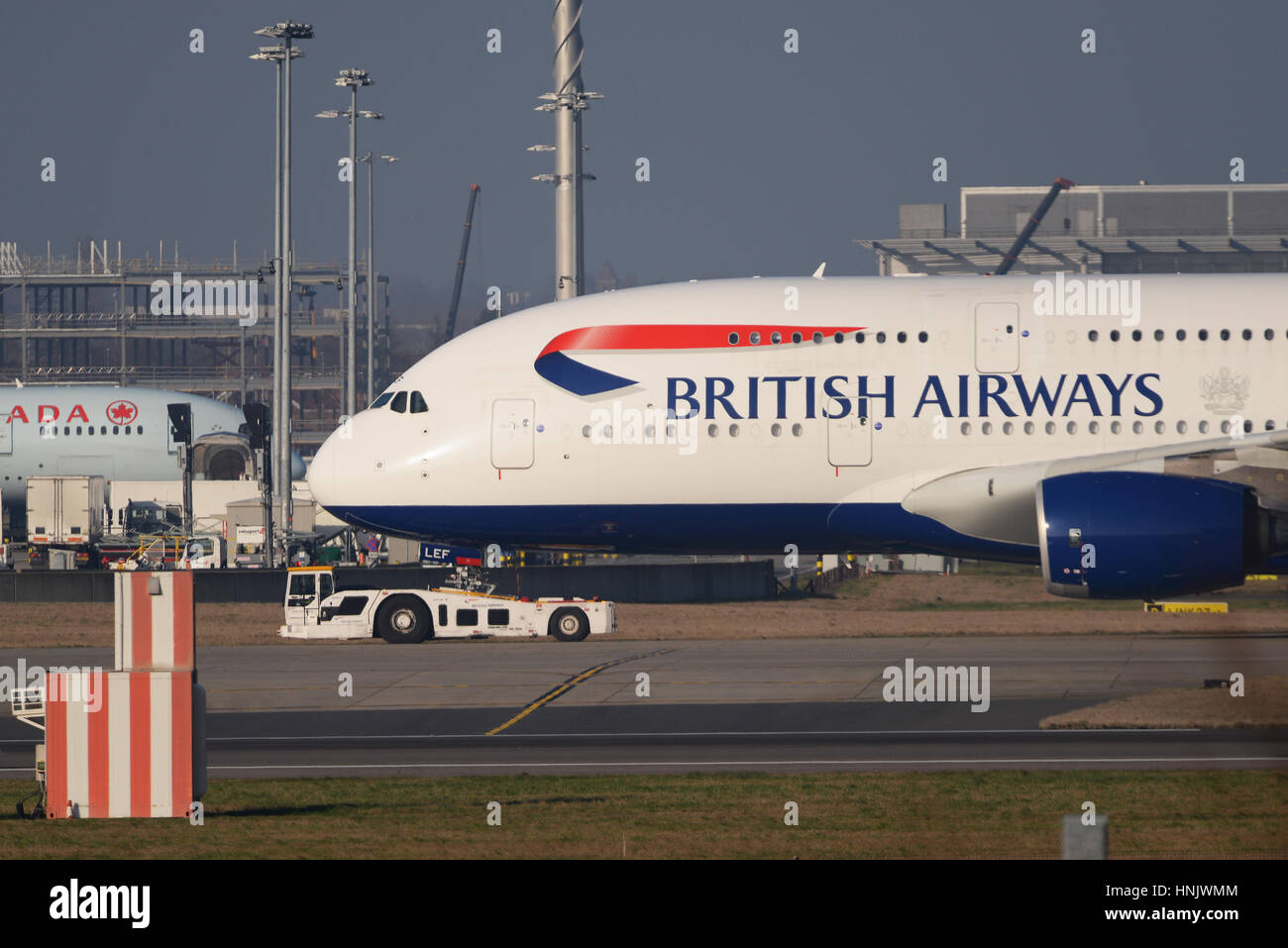 Eine British Airways-Airbus A380 wird gezogen von einem Douglas TBL-600 Schlepper am Flughafen London Heathrow Stockfoto