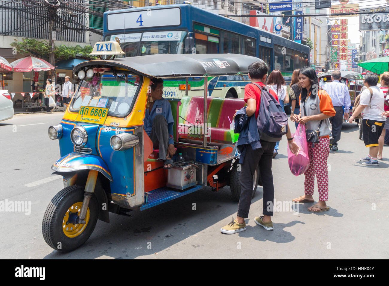 Passagiere, die Verhandlungen über einen Tarif mit einem Tuk-Tuk in Chinatown, Bangkok, Thailand Stockfoto