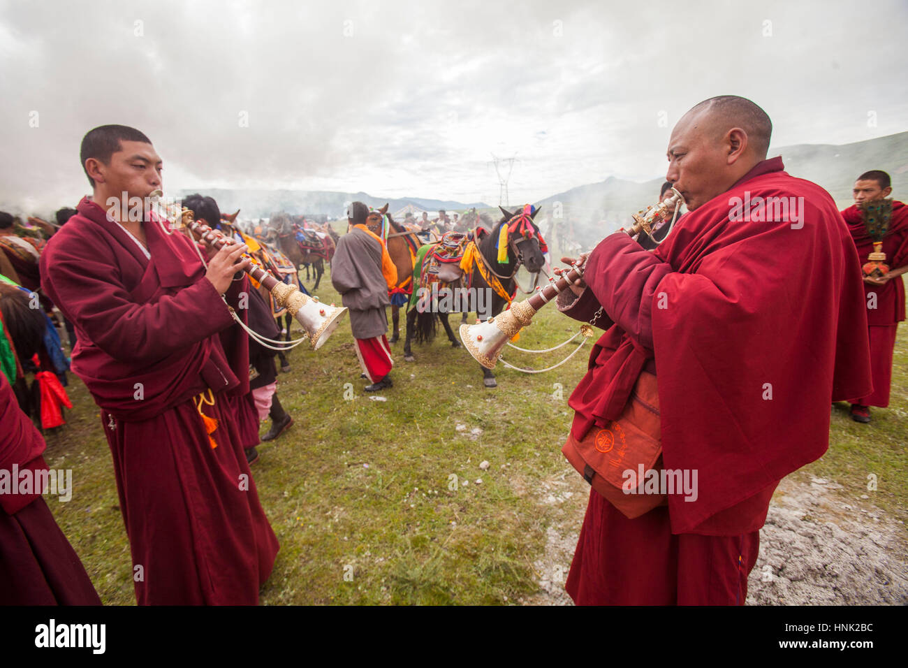 Tibetisch-buddhistische Mönche spielen traditionelle Instrumente um die Reiter vor dem Rennen auf dem Manigango Pferdefest in der tibetischen Platea hoch zu segnen Stockfoto