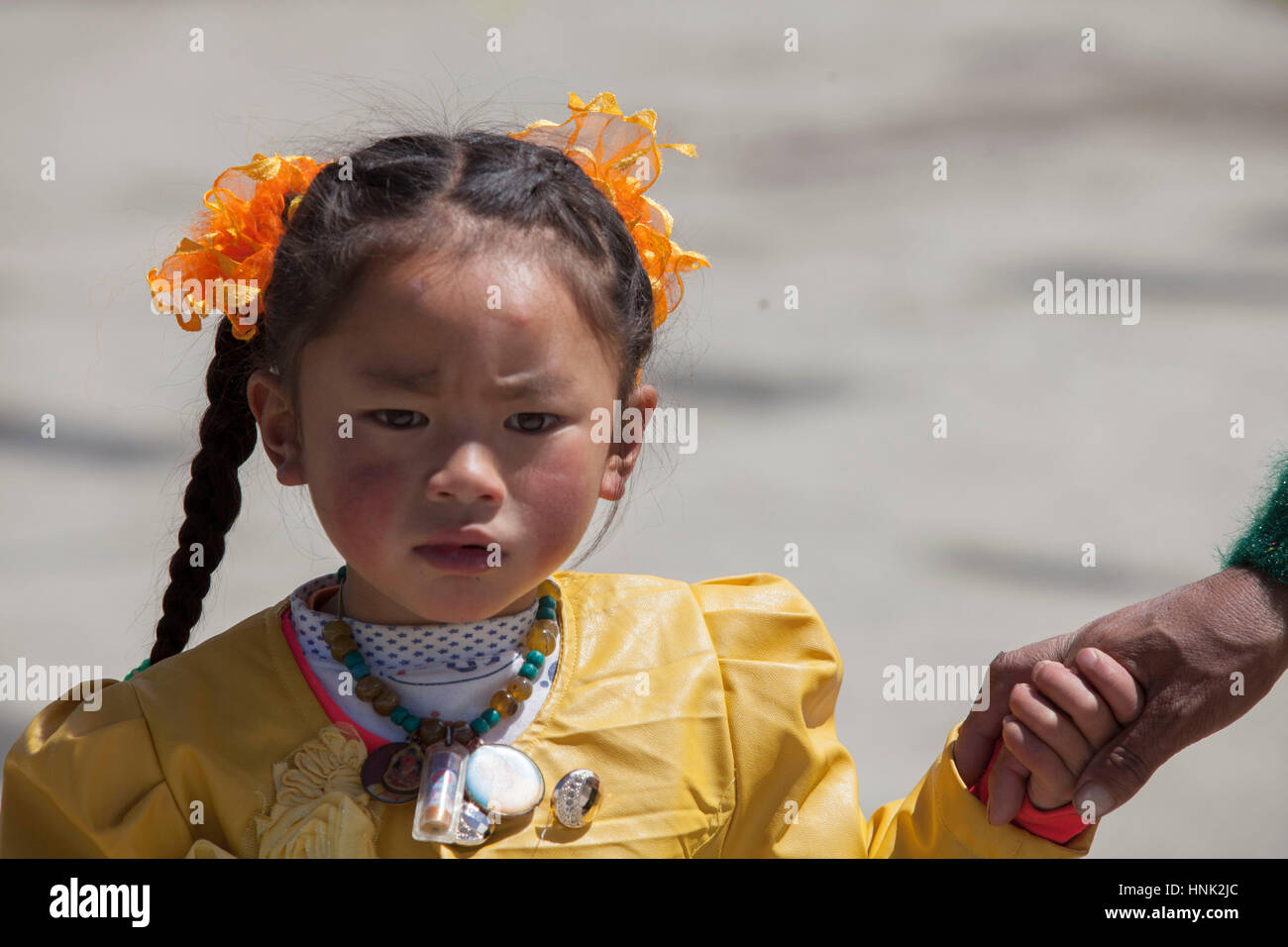Khampa tibetischen Kind besucht Gebetszeremonie in Tagong Kloster, hoch in der tibetischen Hochebene, Sichuan, China Stockfoto