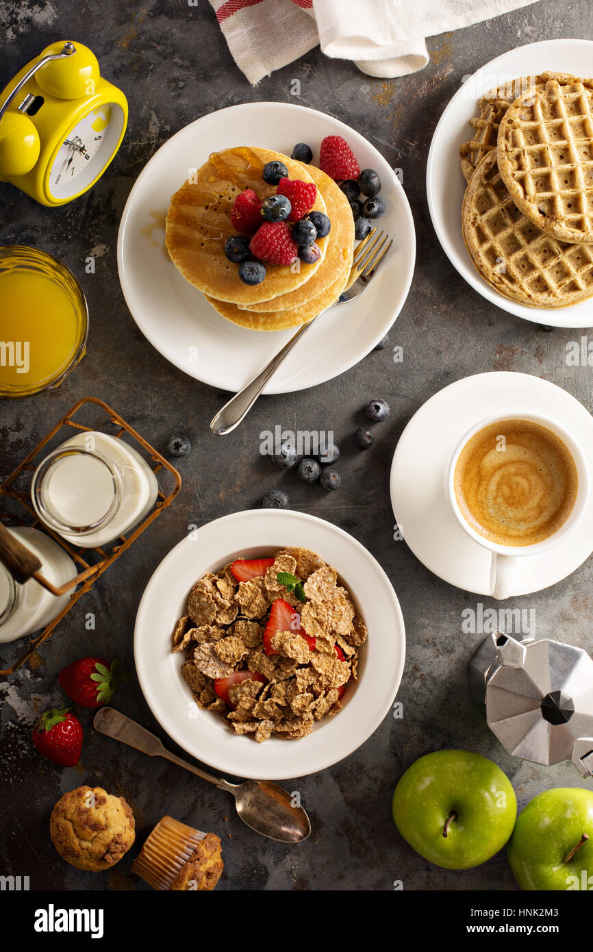Gesundes Frühstück mit Müsli, Obst, Pfannkuchen und Waffeln über Kopf gedreht auf den Tisch Stockfoto