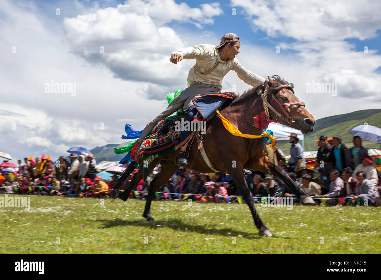 Khampa Mann Reiten während dem Manigango Pferdefest in der tibetischen Hochebene in Sichuan, China. Stockfoto