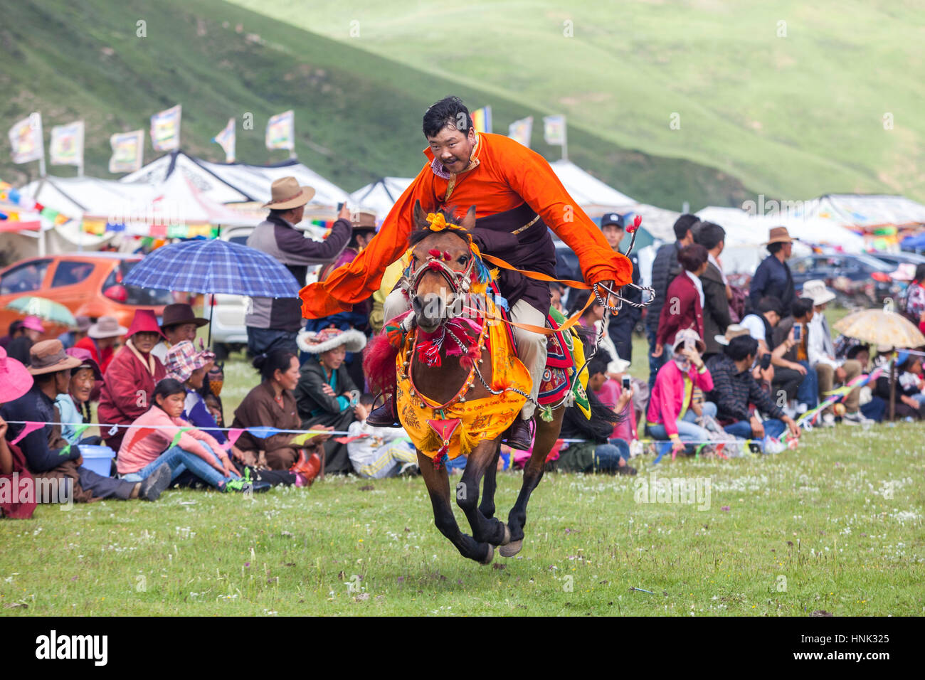Khampa Mann Reiten während dem Manigango Pferdefest in der tibetischen Hochebene in Sichuan, China. Stockfoto