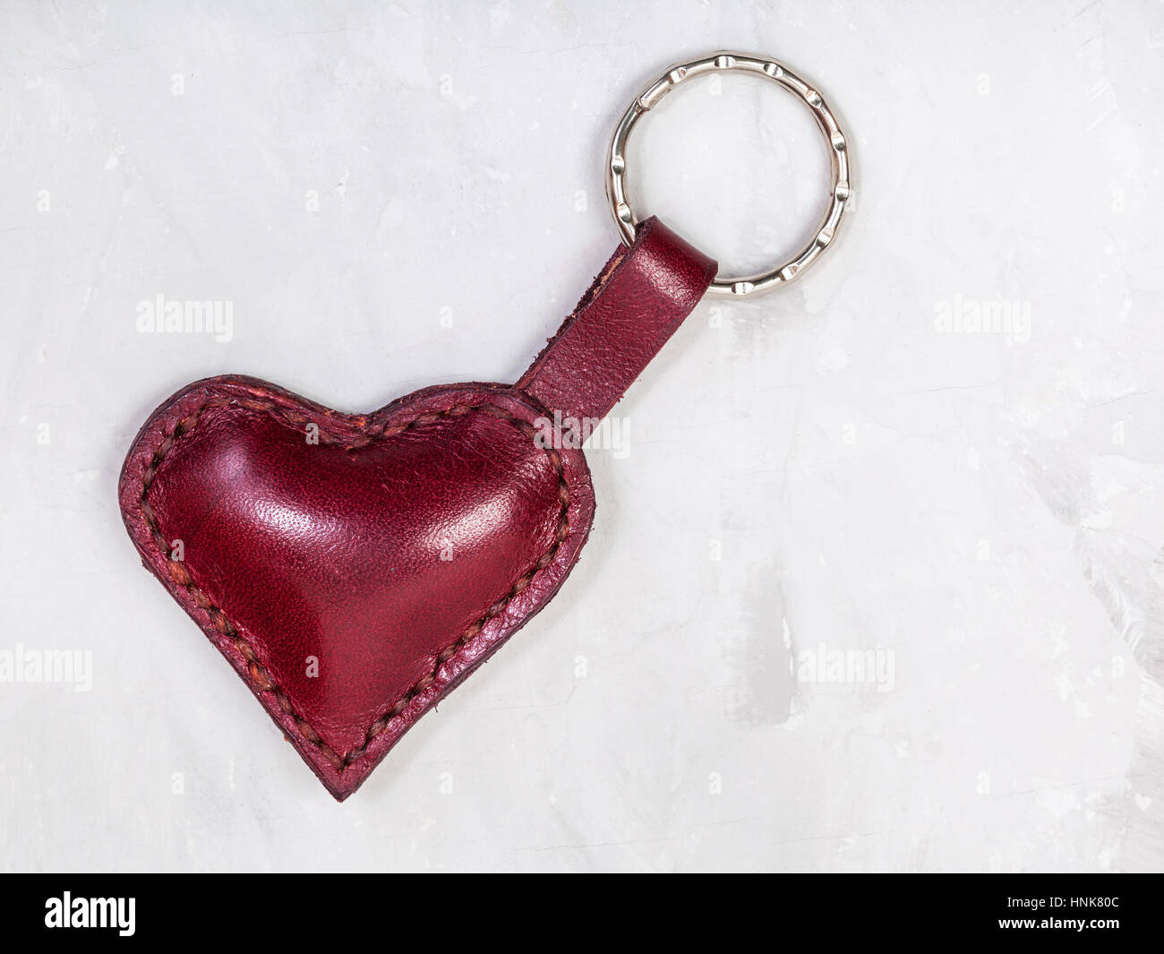 rotem Leder Herz Form Schlüsselbund auf Betonplatte Stockfoto