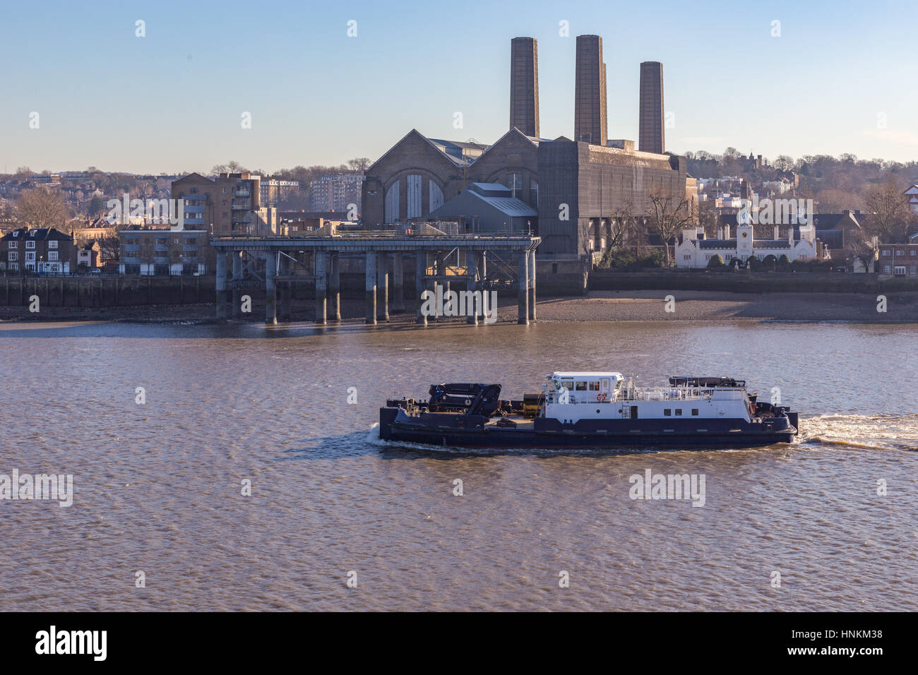 Wartung Boot an einem hellen Tag und zeigt ein Fluss Wartung Schiff flussabwärts, vorbei an der Trinity Hospital und Greenwich Kraftwerk. Stockfoto