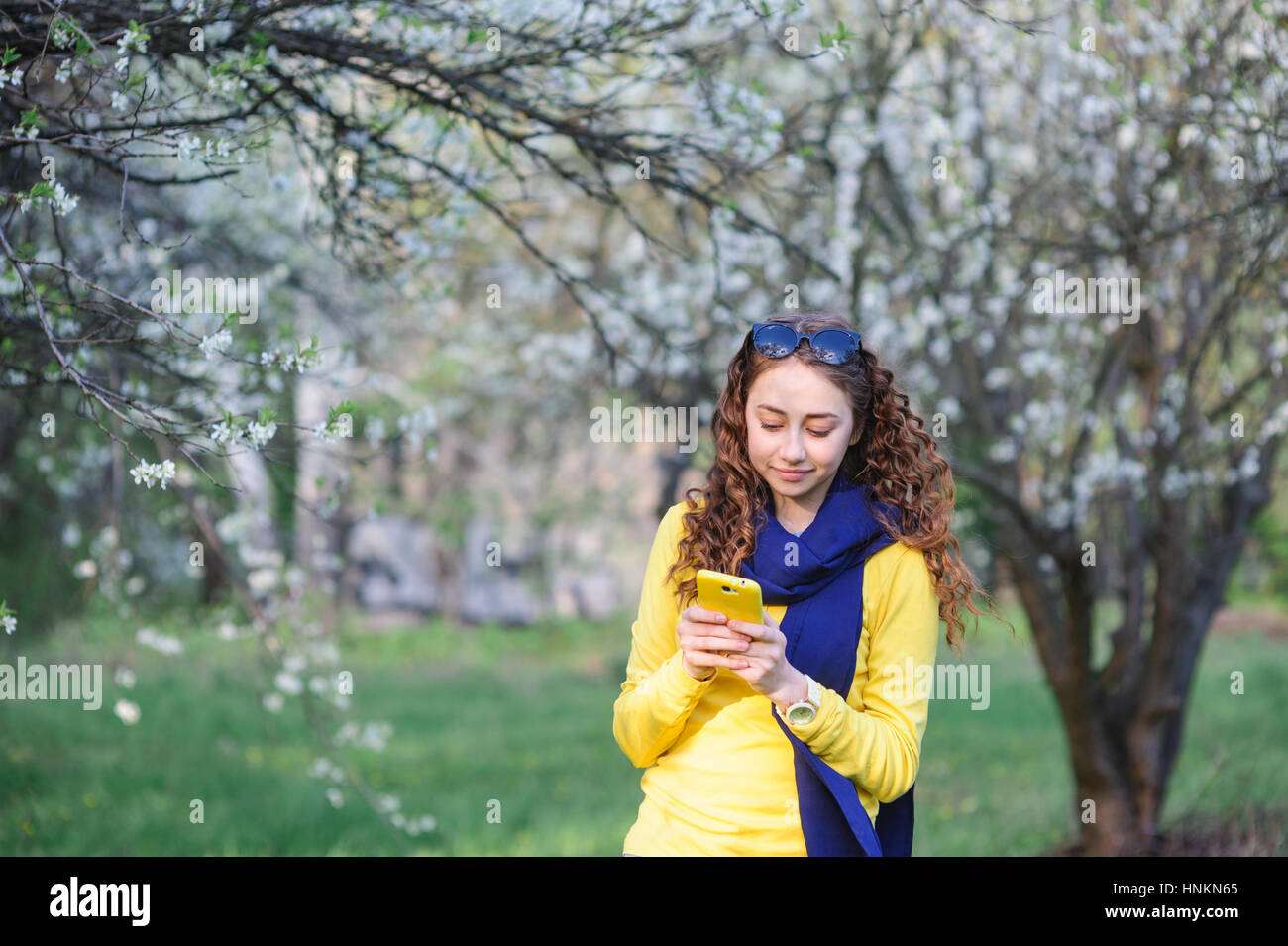schöne junge Frau, die zu Fuß in die üppigen Frühlingsgarten Stockfoto