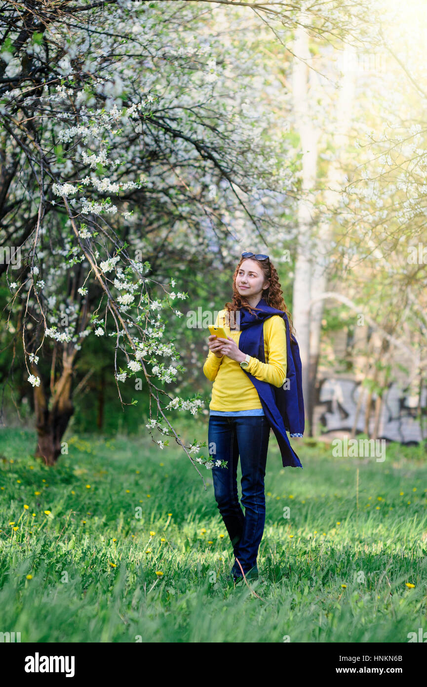 schöne junge Frau, die zu Fuß in die üppigen Frühlingsgarten Stockfoto