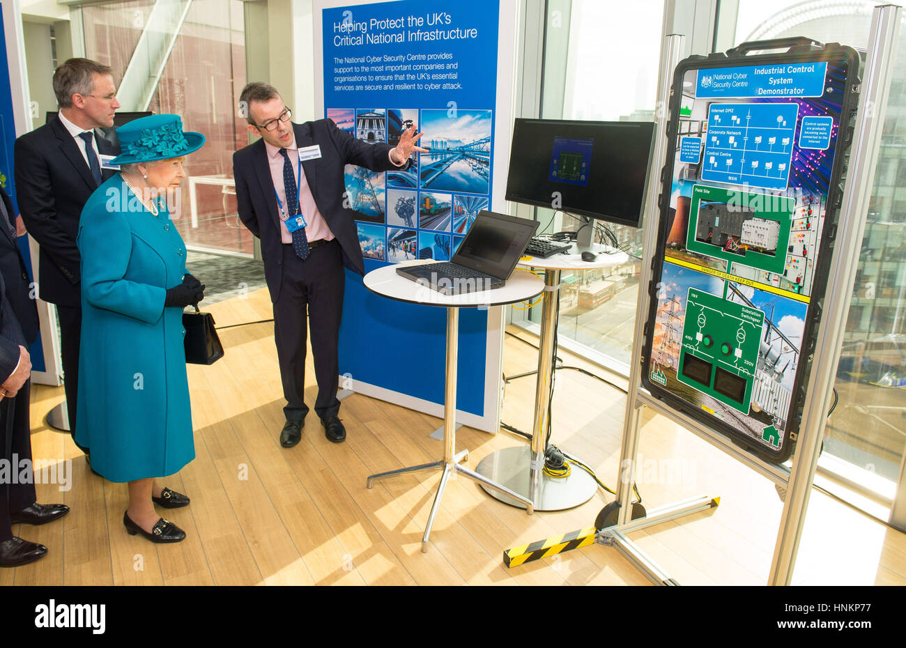 Direktor des Engagements und der Beratung Alex Dewdney (rechts) gibt Queen Elizabeth II eine Demonstration, wie eine Elektrizitätsversorgung Cyber-Angriff bei der offiziellen Eröffnung der National Cyber Security Center (NCSC) in London ausgesetzt sein könnte. Stockfoto