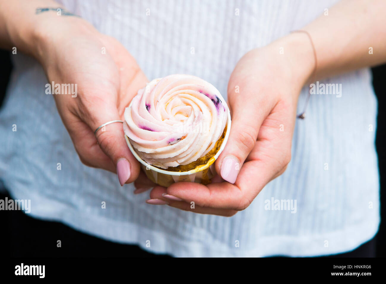 Cooles Mädchen halten cupcake Stockfoto