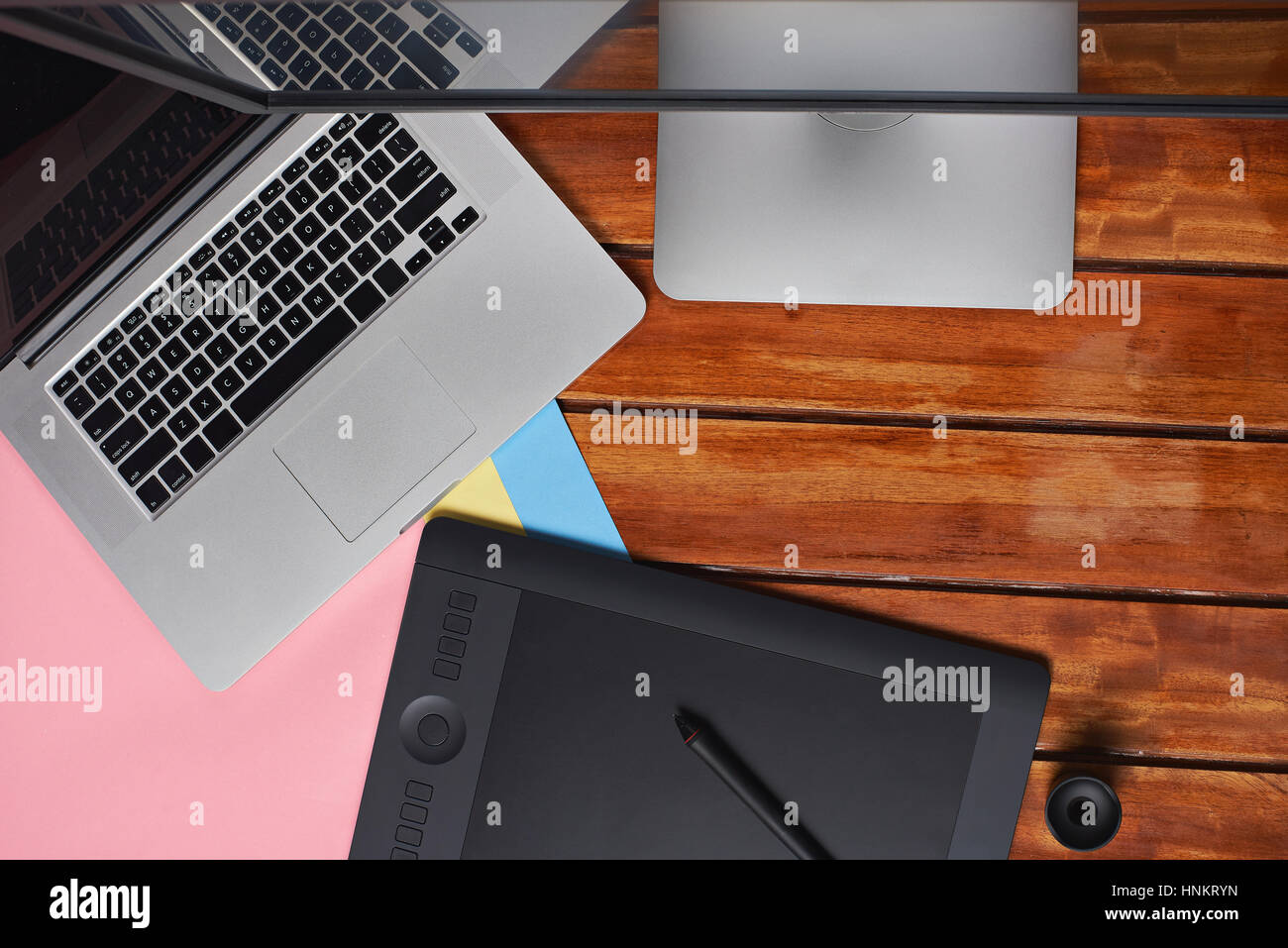 Geräte von Grafik-Designer auf Holztisch mit Laptop und Grafiktablett und große Papiere Stockfoto