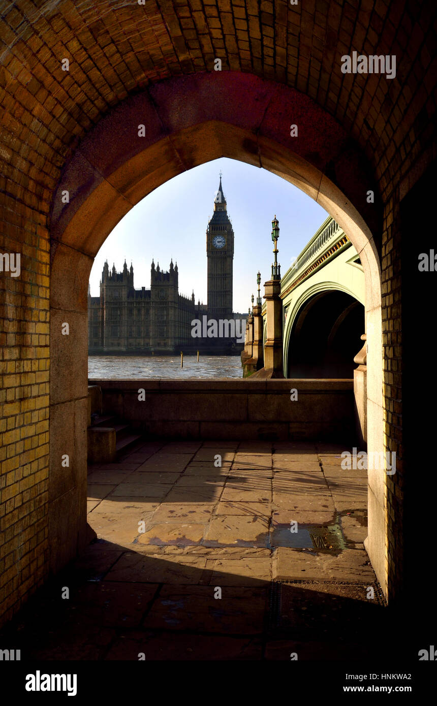 London, England, Vereinigtes Königreich. Big Ben und den Houses of Parliament, gesehen durch einen Bogen unter Westminster Bridge Stockfoto