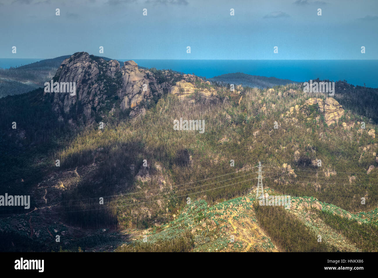Eine Felsenspitze Frouxeira und elektrische Türme Hochspannung, Ferreira DeValadouro, Lugo, Galicien Stockfoto