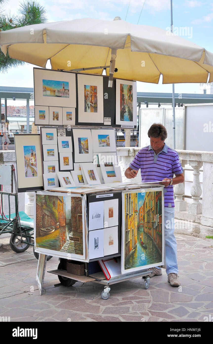 Straße Verkäufer anzeigen seiner Kunst zum Verkauf an den Hafen von Venedig, Italien Stockfoto