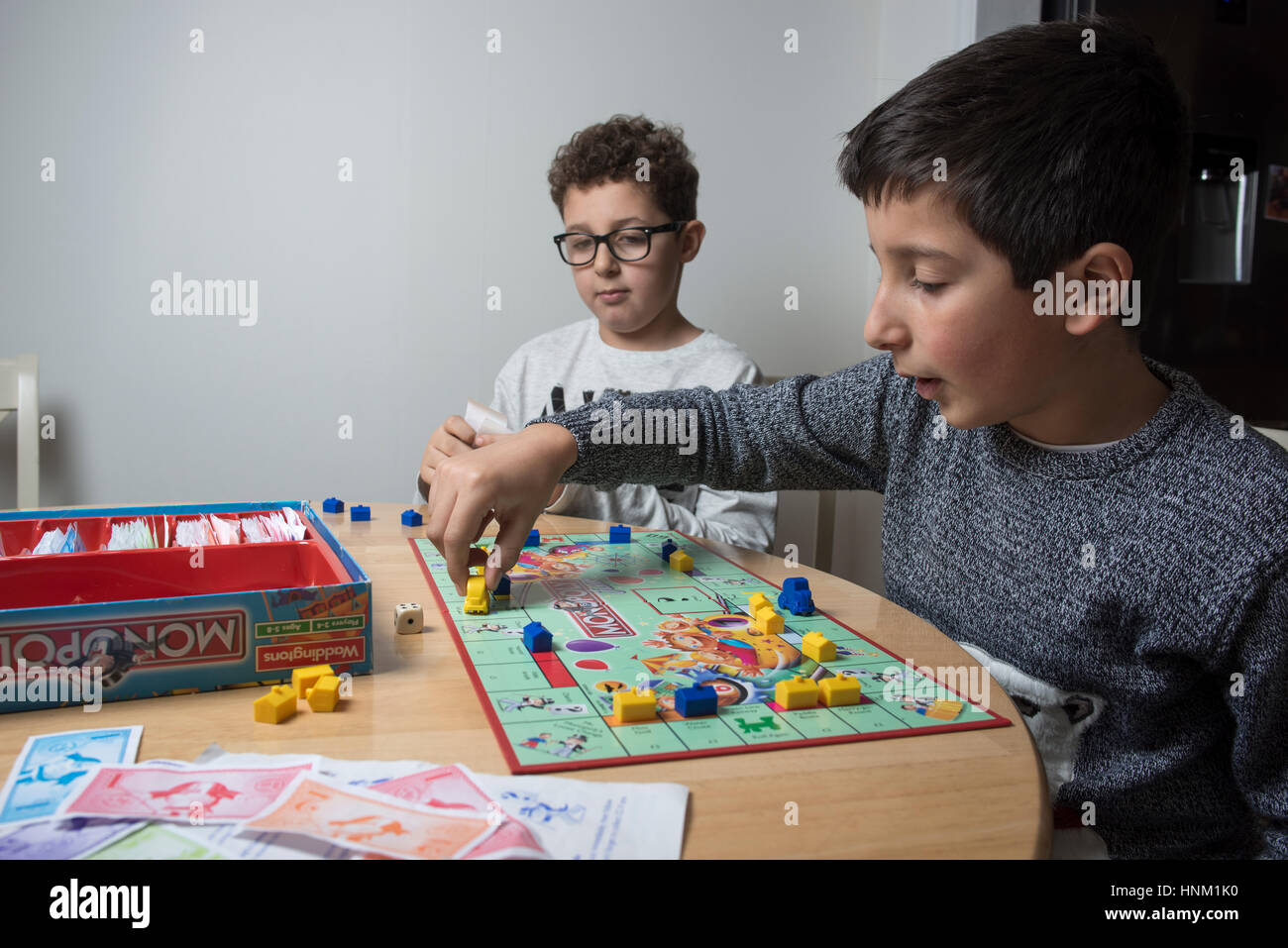 Jungen, 9-10 Jahre alt, spielen Monopoly Brettspiel-selektiven Fokus Stockfoto