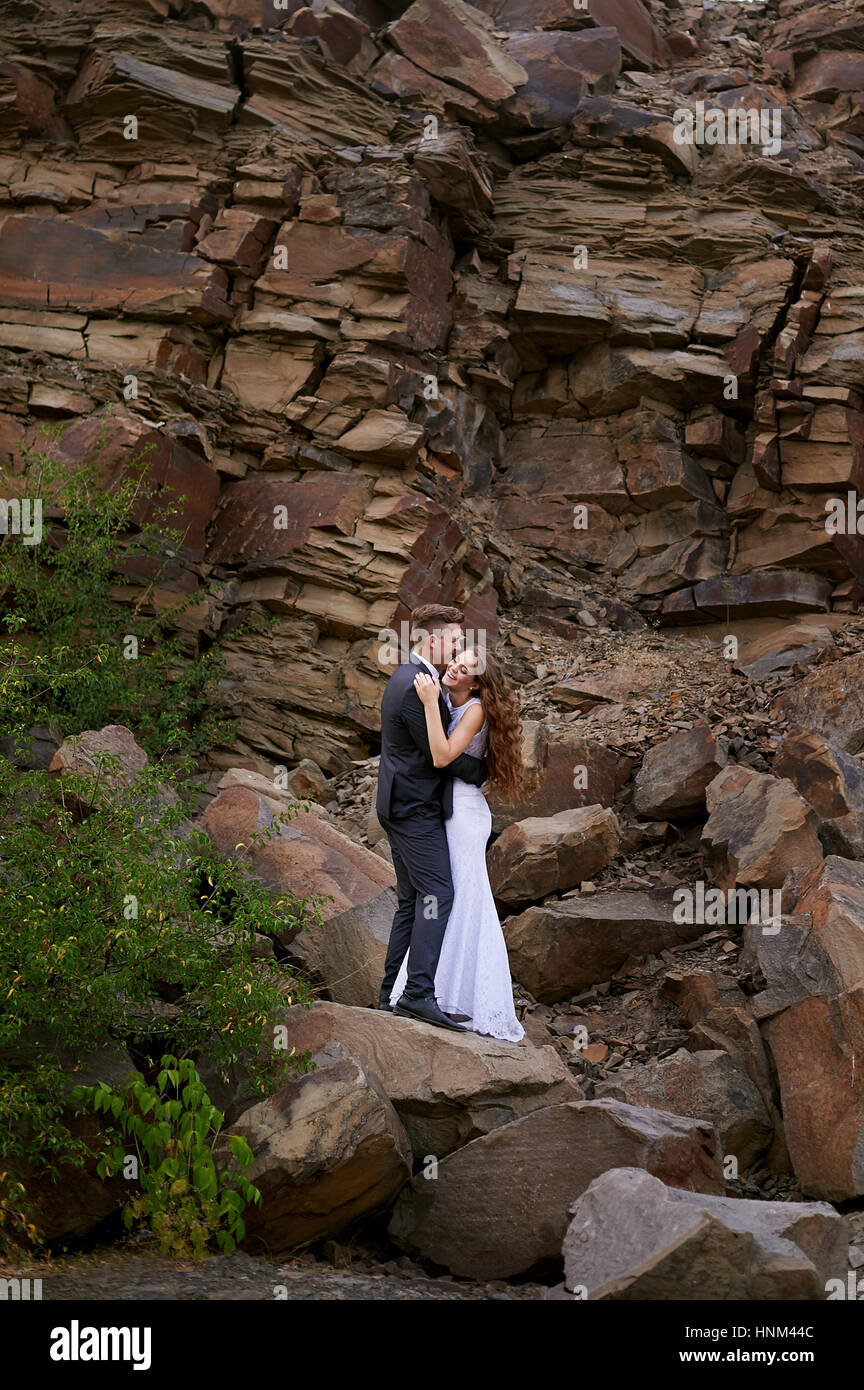 Braut und Bräutigam vor dem Hintergrund der Berge umarmen Stockfoto