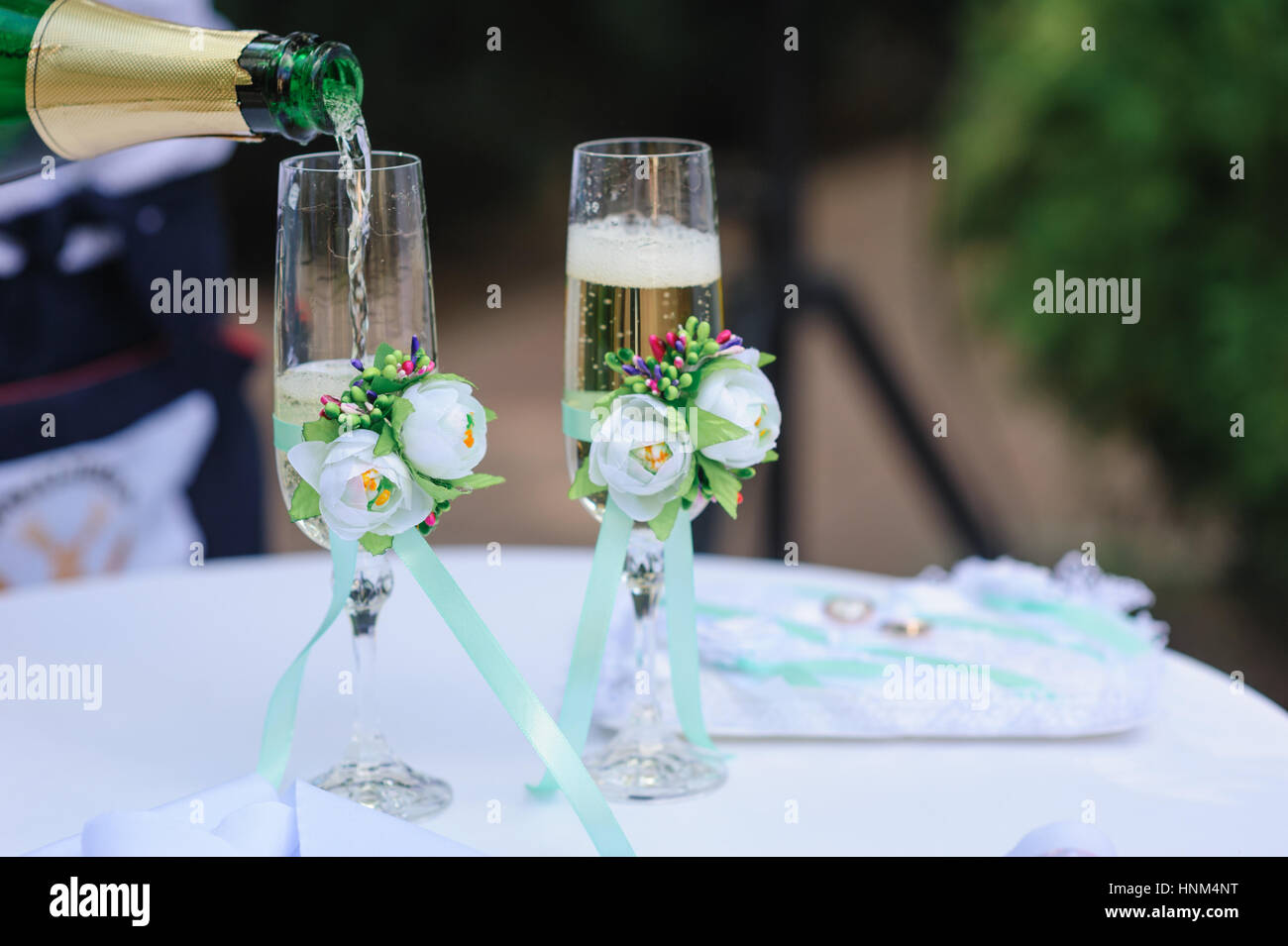 zwei Hochzeit Glas gießen Champagner mit Blumen geschmückt Stockfoto