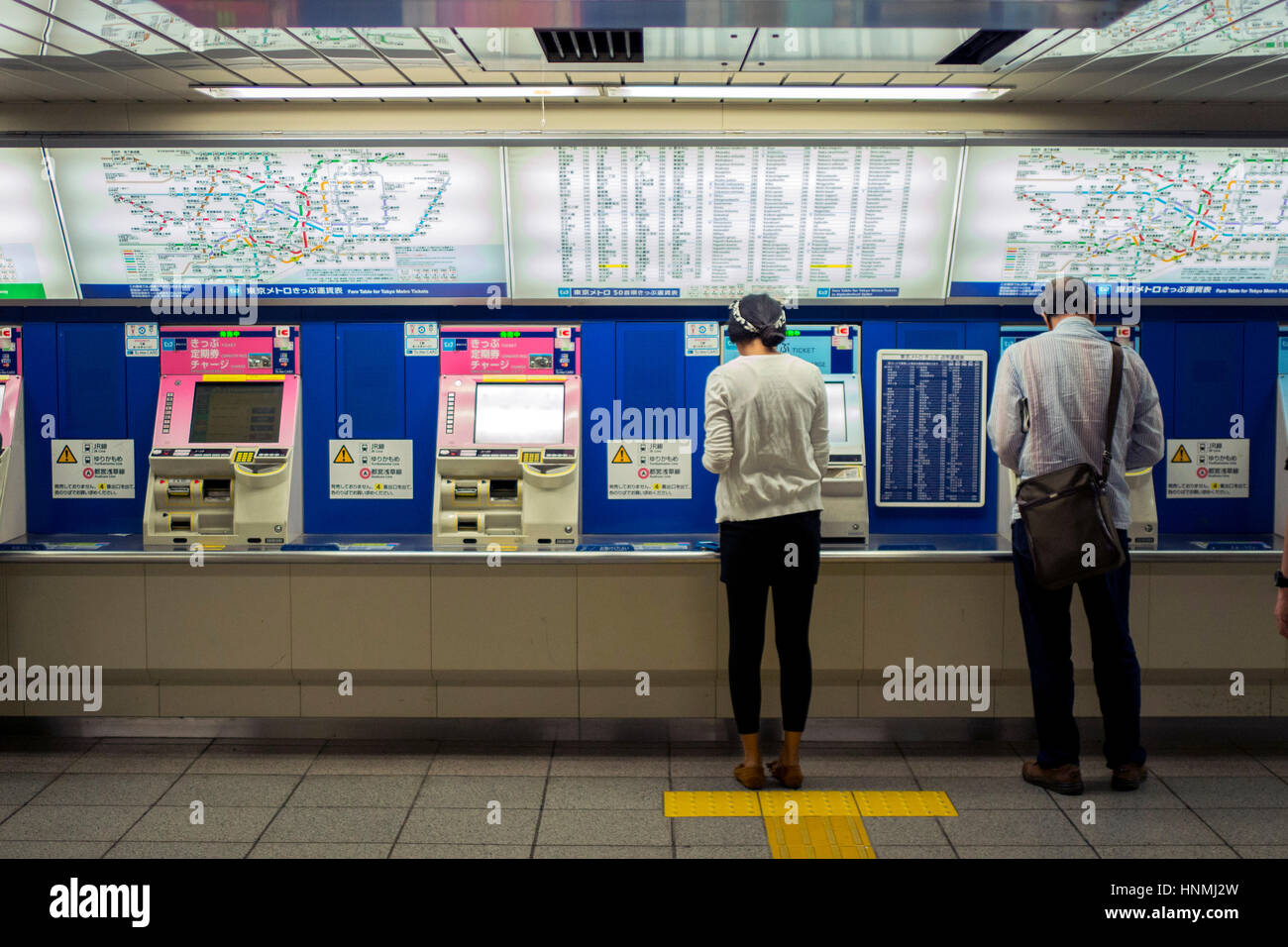 Passagiere der Kauf von Tickets an Automaten an der u-Bahnstation in Tokyo, Japan. Stockfoto