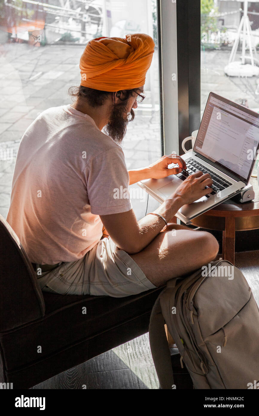 Young-Sikh Mann am Laptop im Café. Stockfoto