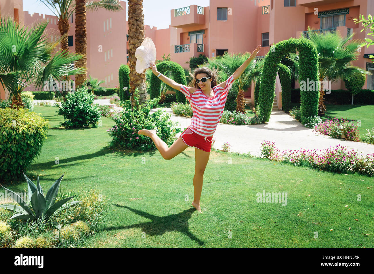 glückliche junge Frau im Park auf dem Rasen springen Stockfoto