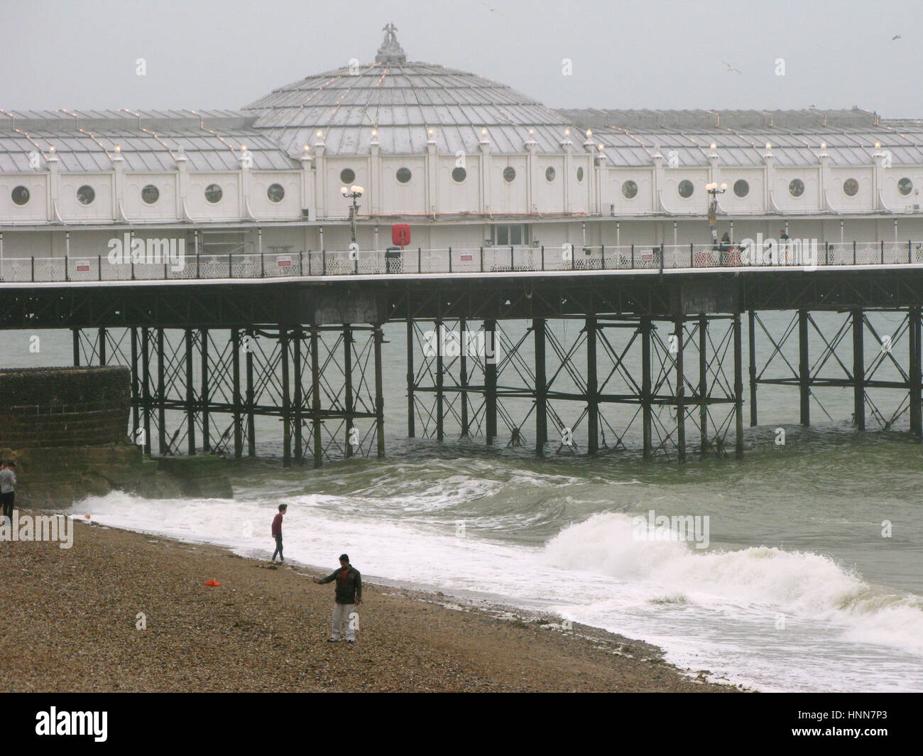 BRIGHTON 2013 England Brighton Pier mit Menschen am Strand bei niedrigem Wasserstand Stockfoto