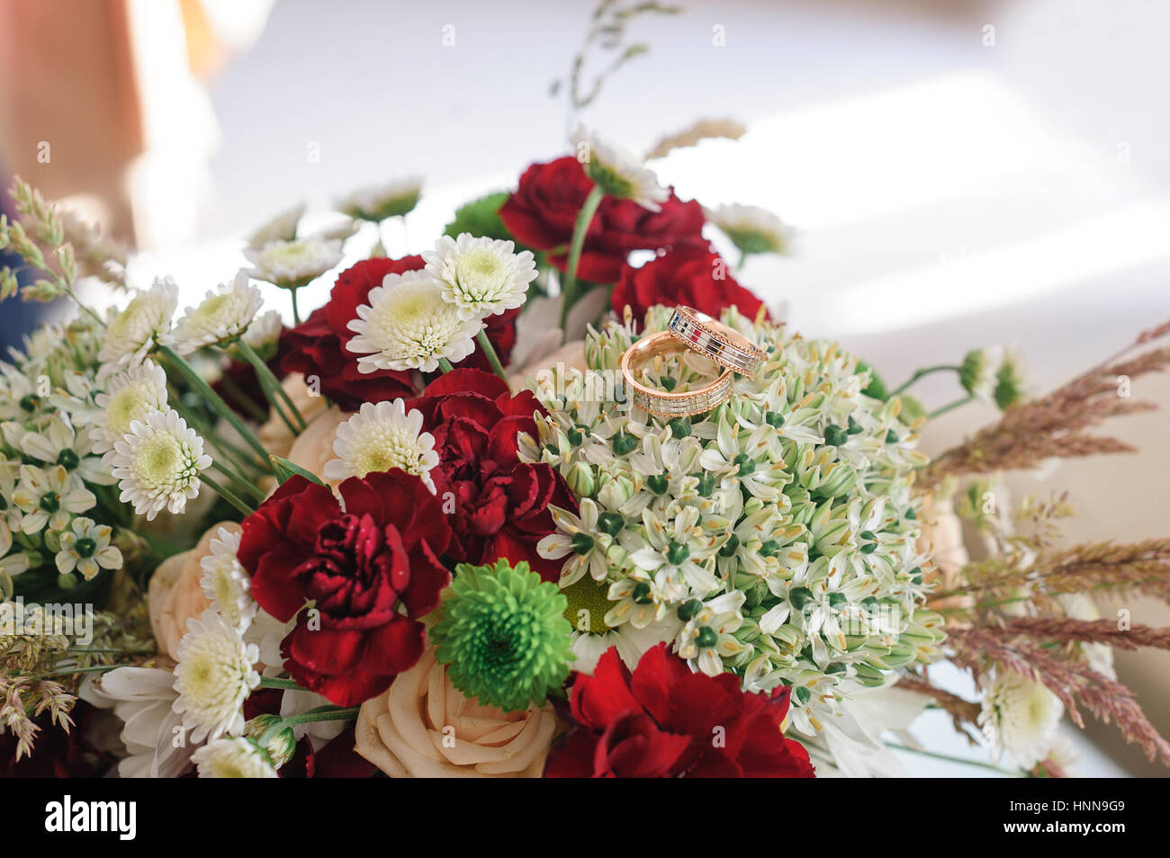 zwei goldene Ringe auf Hochzeit bouquet Stockfoto