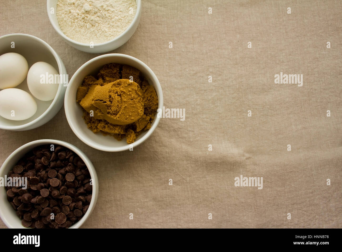 Weißen Schalen mit Zutaten--Schokolade-Chips, Eiern, braunem Zucker und Mehl. Stockfoto