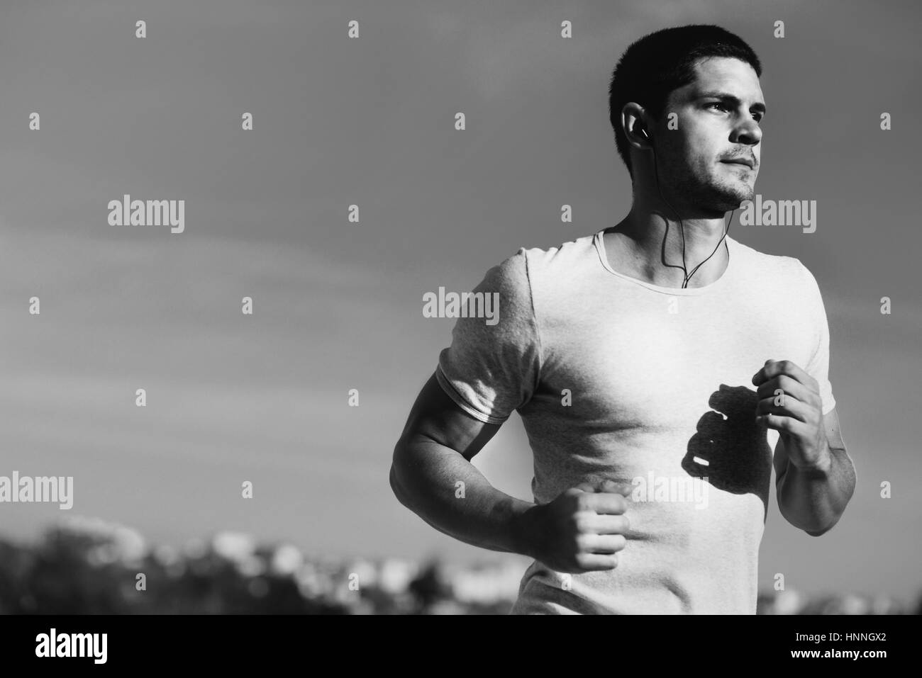 Attraktive starke Athleten laufen entlang des Meeres Stockfoto