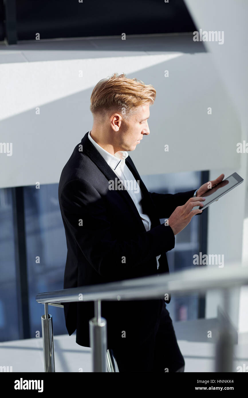 Ein Mann in einem Anzug mit Tablet in der Hand das Amt Stockfoto