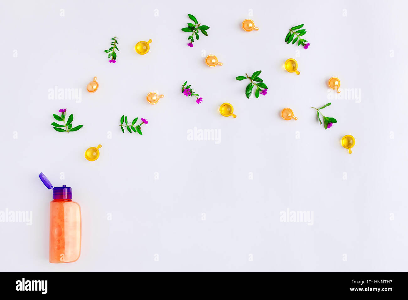 Eine Flasche ätherisches Öl mit frischen Wiese Kräuter und Blumen auf weißem Hintergrund. Flach legen, Top Aussicht, natürliche Stockfoto