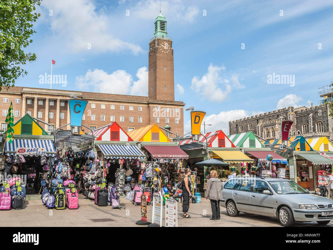 Marktstände am Marktplatz von Norwich mit dem Rathaus im Hintergrund, Norfolk, England, Großbritannien. Stockfoto