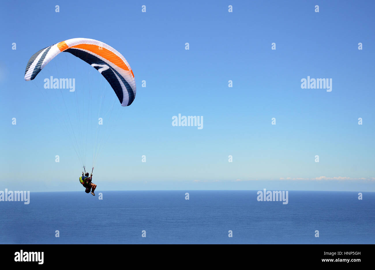 Extreme Sport Gleitschirmfliegen über dem Ozean durch klaren blauen Himmel. Platz für Text zu kopieren. Stanwell Tops, New-South.Wales, Australien Stockfoto