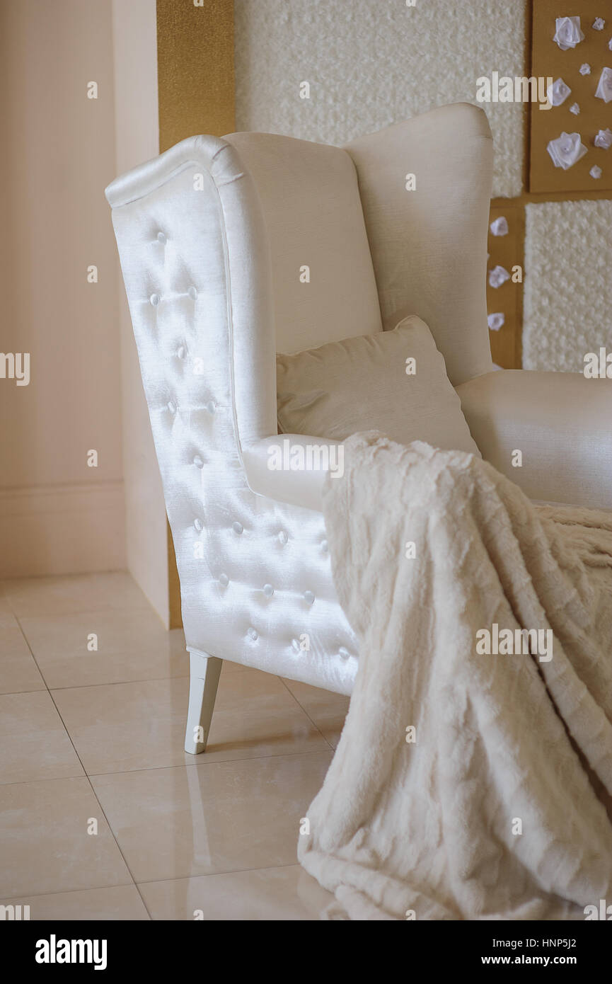weißer Stuhl mit einer Decke im studio Stockfoto