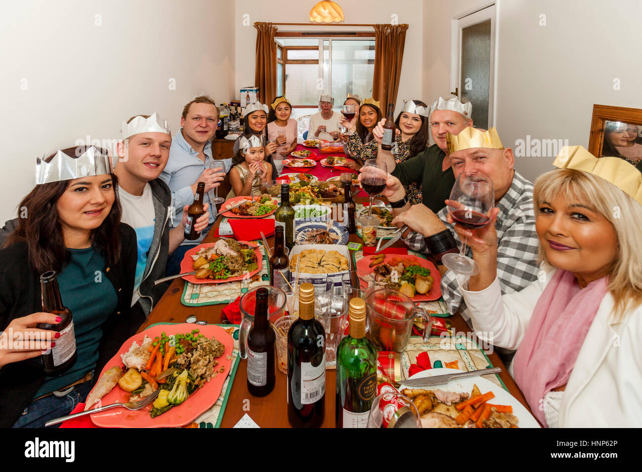 Eine Multi-ethnische Familie sitzen nach unten, um eine traditionelle Weihnachten Mittagessen, Sussex, UK Stockfoto