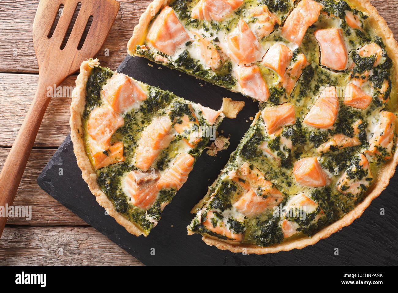 Herzhafte Speisen: in Scheiben geschnitten-Tarte mit Lachs, Spinat und Sahne close-up auf dem Tisch. horizontale Ansicht von oben Stockfoto