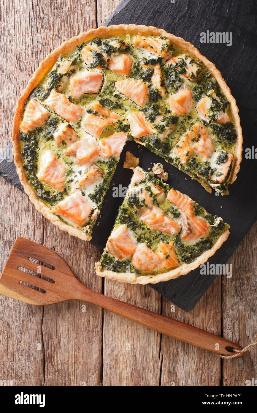 Herzhafte Speisen: in Scheiben geschnitten-Tarte mit Lachs, Spinat und Sahne close-up auf dem Tisch. vertikale Ansicht von oben Stockfoto